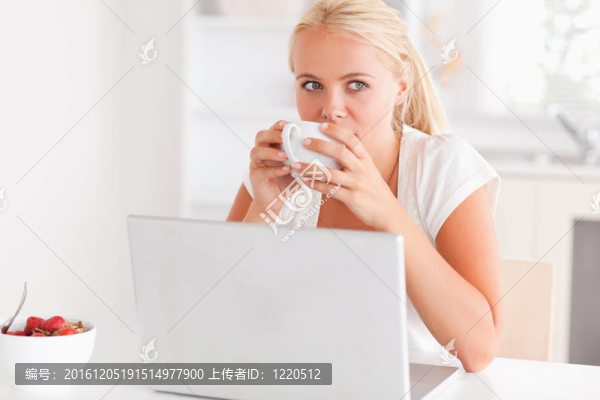 用筆記本電腦喝茶的女人