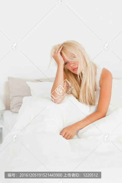 一個漂亮女人坐在床上的畫像