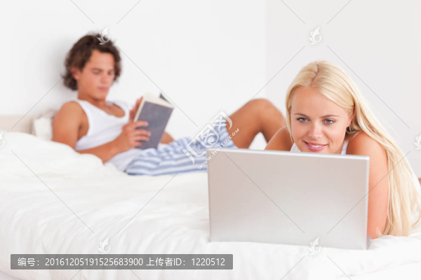 當未婚夫正在閱讀時，女人正在使用筆記本電腦