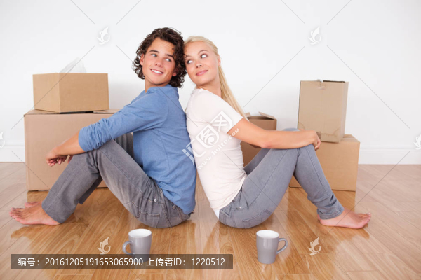 可愛(ài)的情侶坐在地板上