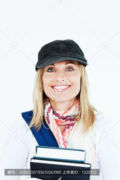 一個漂亮的女人的帽子和書微笑在相機對白色背景