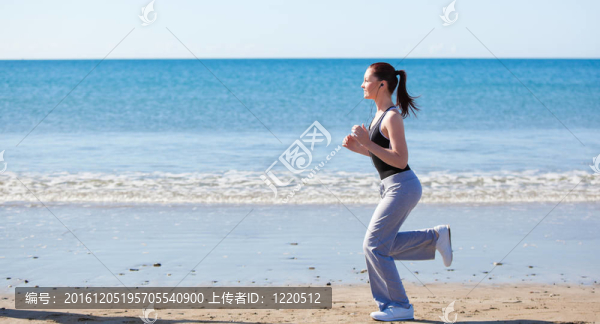 苗條的女人在沙灘上奔跑