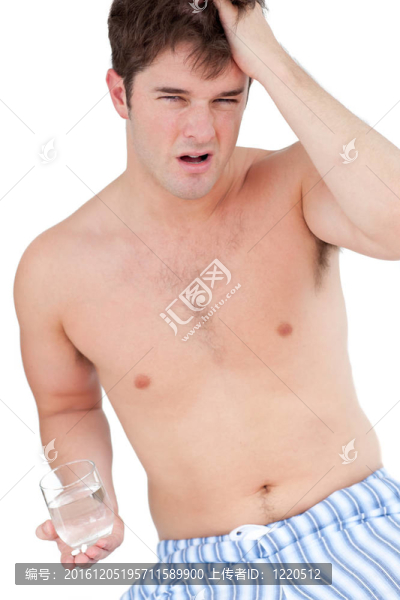 精疲力竭的男子穿著睡衣拿著一杯水看著相機(jī)對(duì)白色背景