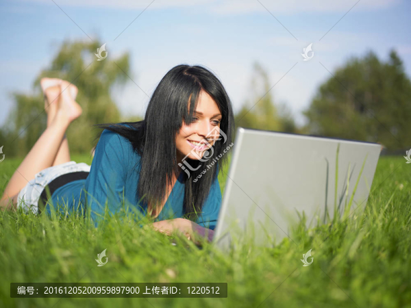 在公園里使用筆記本電腦的年輕女人
