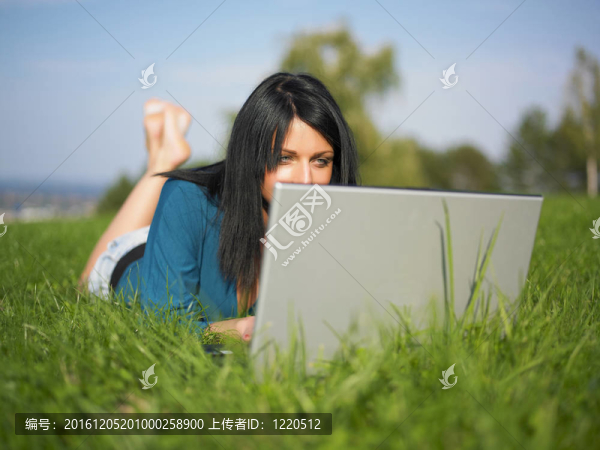 在公園里使用筆記本電腦的年輕女人