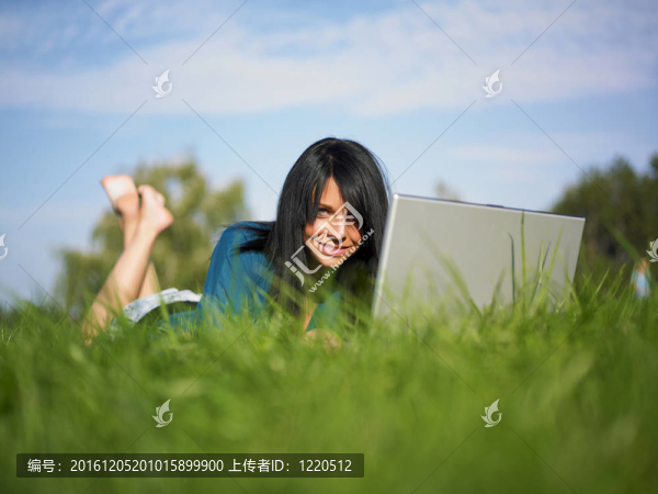 在公園里使用筆記本電腦的年輕女人