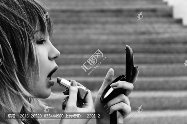 美麗的年輕女子口紅和鏡子