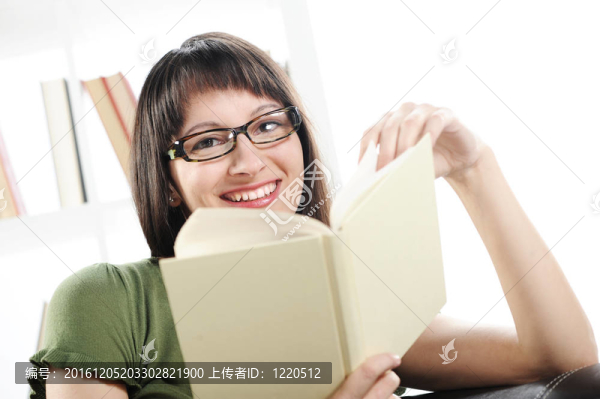 年輕的女人與書的書架在BAC明亮的畫面；