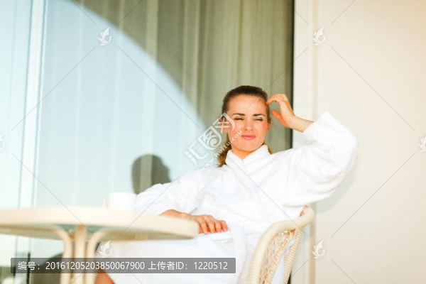 在浴袍坐在桌邊上的年輕女子和思維平臺