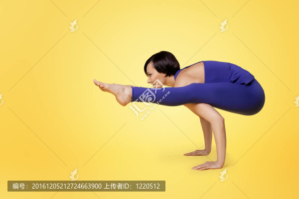 女人做瑜伽手臂平衡和微笑