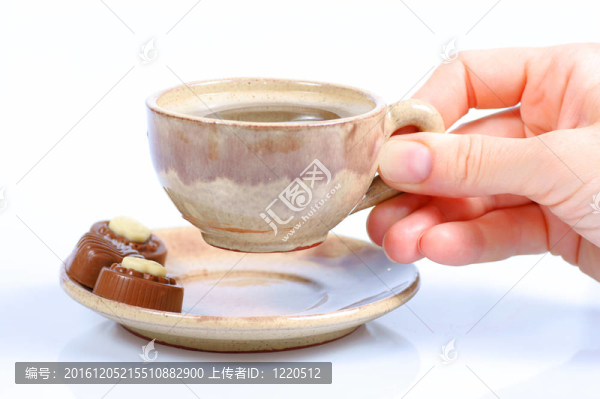 果仁巧克力；杯；黑咖啡和女性手上白色
