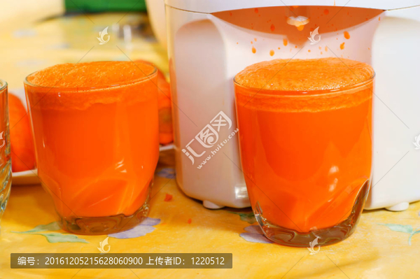 玻璃中的胡蘿卜汁；榨汁機