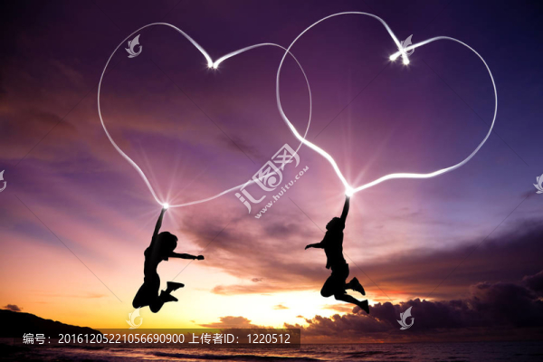 年輕的夫婦跳圖連接心手電筒在空中海灘日出前