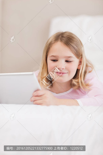 一個微笑的小女孩用平板電腦畫像