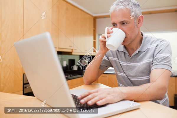 快樂(lè)的人用筆記本一邊喝咖啡