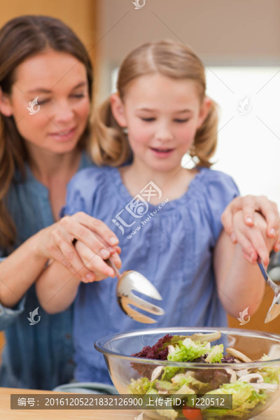 一個帶著女兒準備沙拉的女人肖像