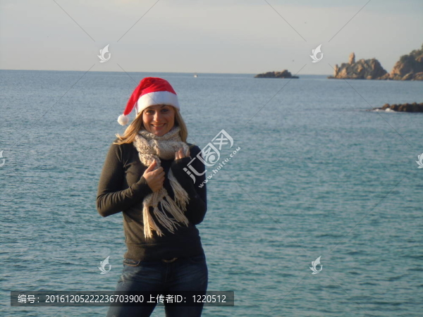 在沙灘上和圣誕老人帽子的女人