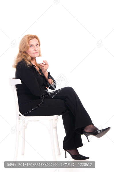 老婦人用杯子在椅子上
