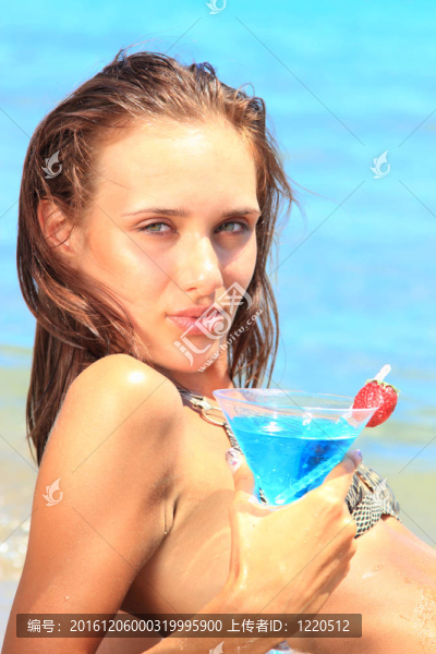 海灘上的年輕女人伴著雞尾酒