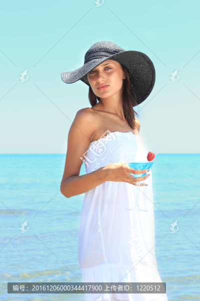 海灘上的年輕女人伴著雞尾酒