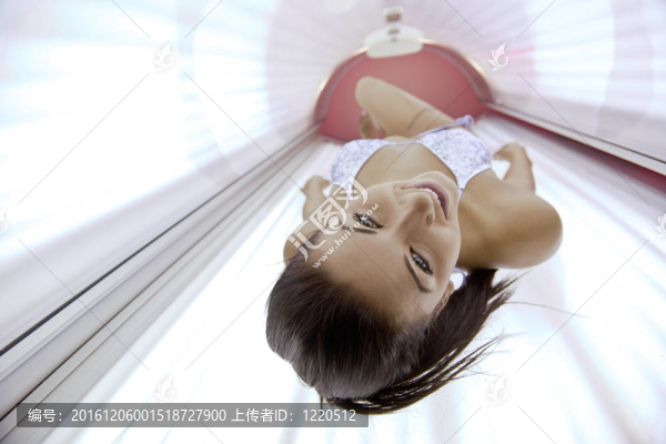 美麗的年輕女子曬日光浴