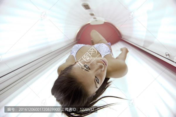 美麗的年輕女子曬日光浴