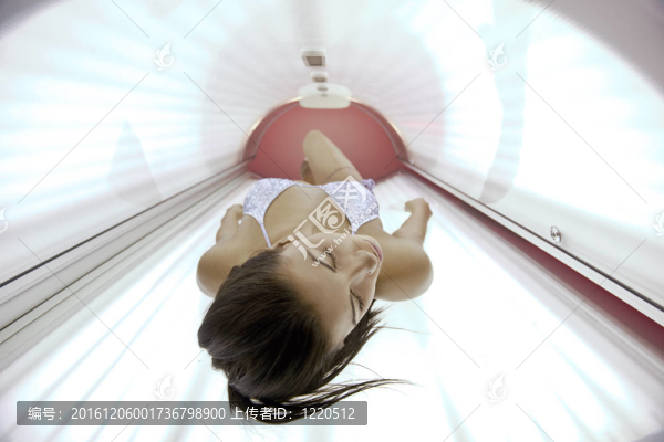 美麗的年輕女子曬日光浴