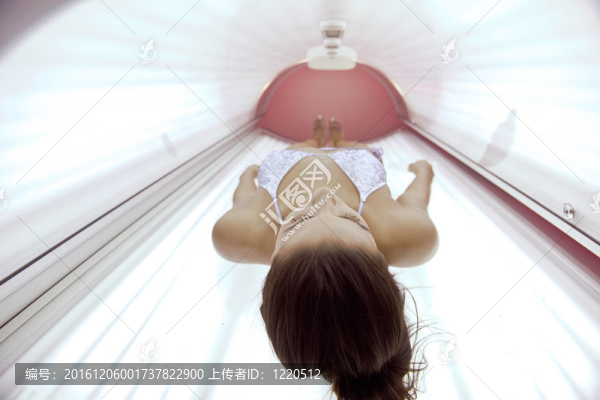 美麗的年輕女子曬日光浴