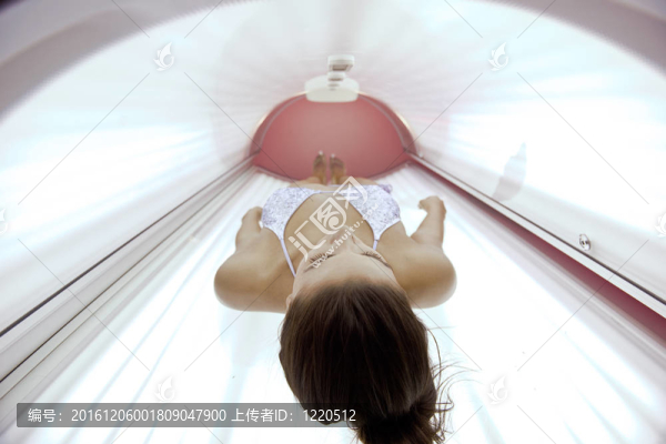 美麗的年輕女子曬日光浴