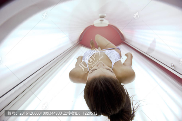 美麗的年輕女子曬日光浴