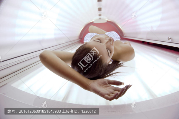 美麗的年輕女子曬日光浴