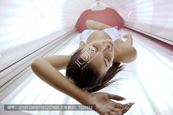美麗的年輕女子曬日光浴