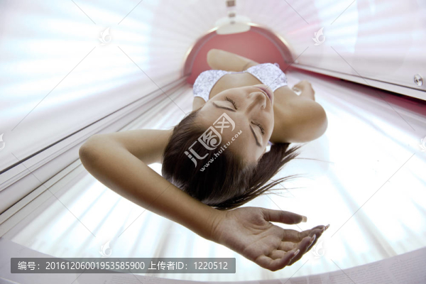美麗的年輕女子曬日光浴