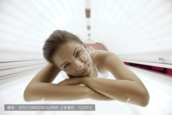 美麗的年輕女子曬日光浴