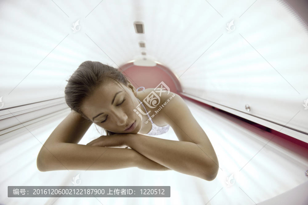 美麗的年輕女子曬日光浴