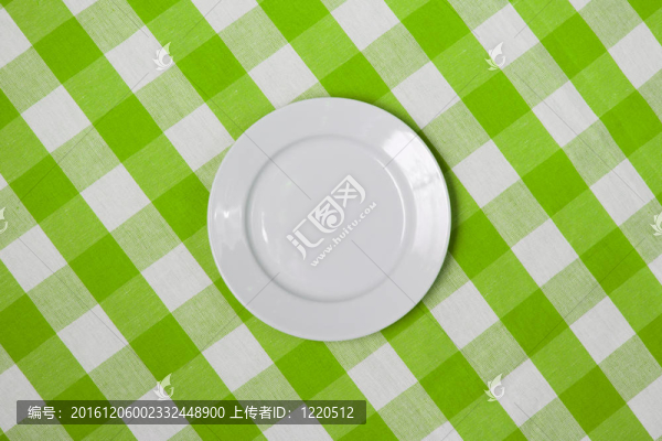 白色的圓形板上綠色的格子桌布
