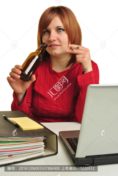 一個(gè)年輕女人在她的辦公桌旁喝酒