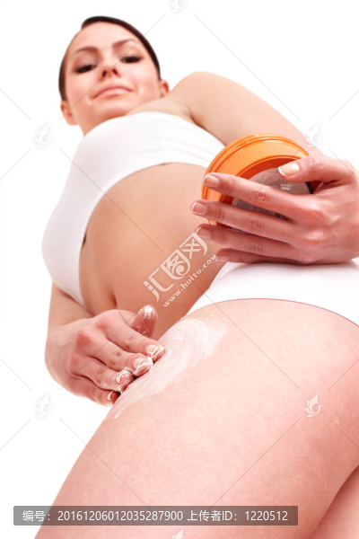 年輕女士在化妝品上涂化妝品霜。