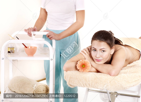 美容按摩床上的年輕女子。