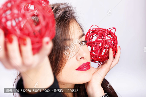 女子拿著兩個(gè)紅球