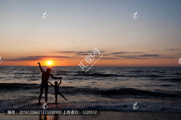 父親和他的douther剪影在日落海灘