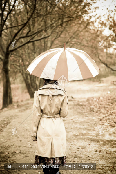下雨天在公園里帶著雨傘和圍巾的女孩。照片與自然色彩的復(fù)古風(fēng)格。