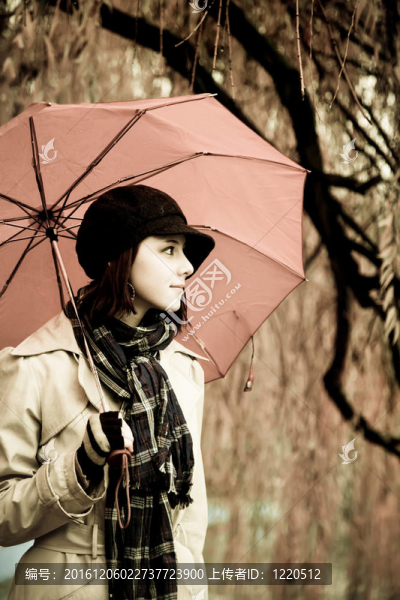 下雨天在公園里帶著雨傘和圍巾的女孩。照片與自然色彩的復(fù)古風(fēng)格。
