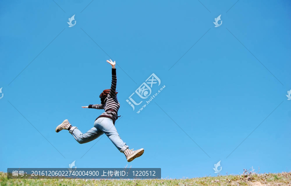 女孩在草地上跳。