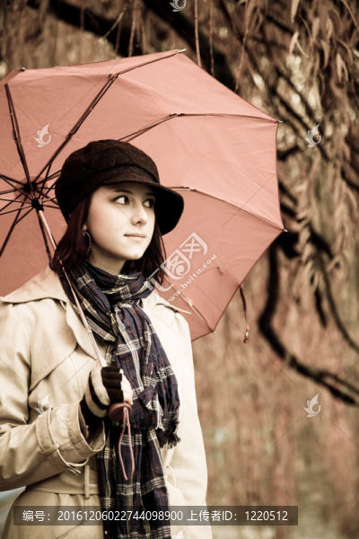 下雨天在公園里帶著雨傘和圍巾的女孩。照片與自然色彩的復(fù)古風(fēng)格。