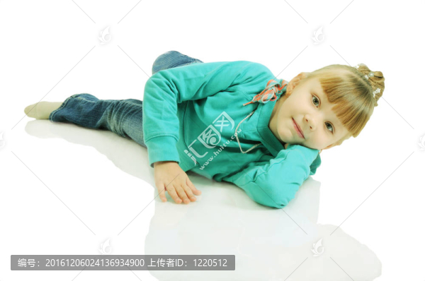一個(gè)美麗的小女孩躺在地板上。白色背景上孤立