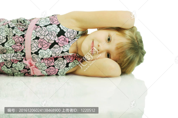 一個美麗的小女孩躺在地板上。白色背景上孤立
