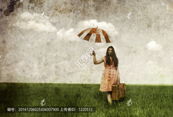 黑發(fā)女巫在春油菜田傘和箱子。舊圖像風(fēng)格照片。