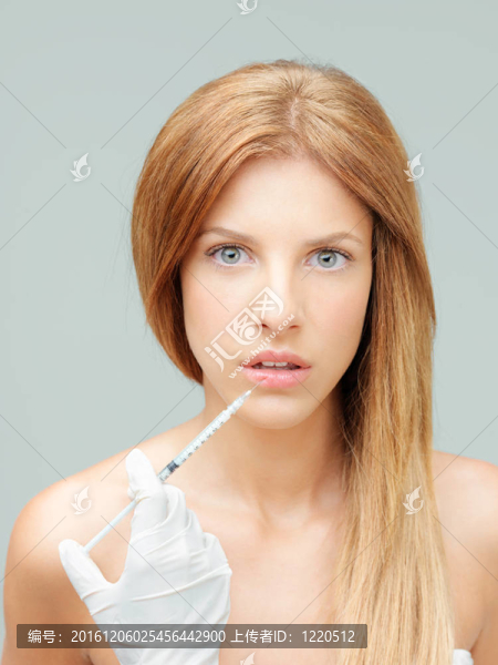 年輕的女醫(yī)生的手嘴唇注射膠原