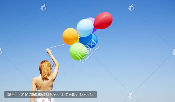 紅發(fā)女孩用彩色氣球在藍色的天空背景。